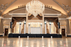 Elegant white wedding DJ setup at The Venetian in Garfield NJ with six moving head lights, pixel tube lighting and professional speakers.
